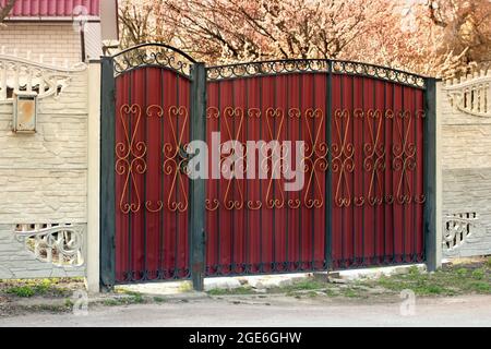 Beautiful fence near the house. Spring. Trees are blooming Stock Photo