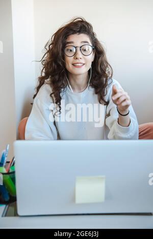 Digital communication. Business technology. Online education. Woman with curly hair schooling from home. Stock Photo