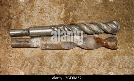 Two Masonry Drill Bits on a Cement Background Stock Photo