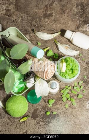 SPA organic natural cosmetic with green tea. Sea salt, soap, essential oil. Massage concept. Dark stone marble background, top view Stock Photo