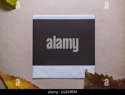 Blank photo frame with autumn leaves on brown background as template for graphic design. space for your logo or text. Stock Photo
