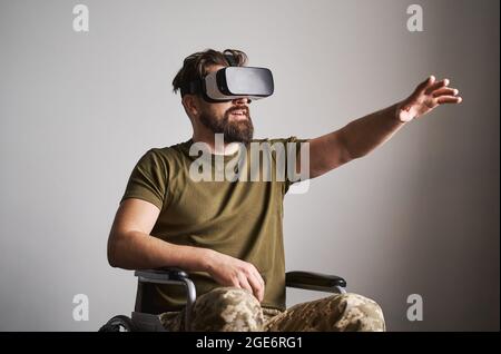 Disabled ex-serviceman in a wheelchair using a VR headset Stock Photo