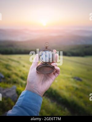 Man with compass in hand on mountains road. Travel concept. Landscape photography Stock Photo