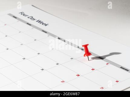 Printed calendar for a 4 day working week showing weekend days in red in new approach to productivity Stock Photo