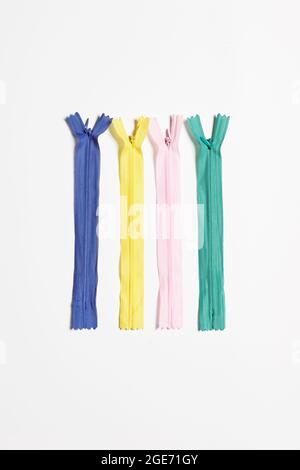 Sewing zippers on blue. Zippers stripes with sliders pattern for handmade sewing tailoring on white background Stock Photo