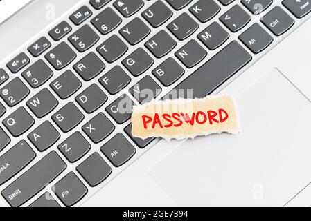 Password text on torn paper on top of laptop keyboard Stock Photo