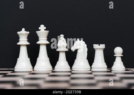 Set of White Chess Pieces on Black Background Stock Photo