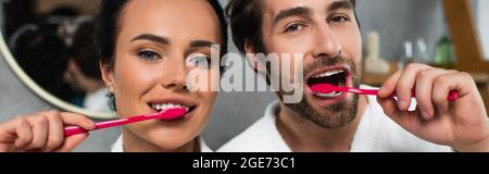 happy young couple brushing teeth, banner Stock Photo