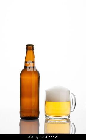 Brown full bottle of beer and glass with beer and foam isolated on white background Stock Photo