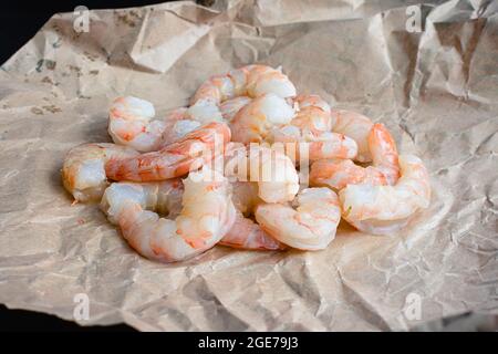 Raw Shrimp on Brown Butchers Paper: Uncooked peeled and deveined shrimp on brown paper Stock Photo