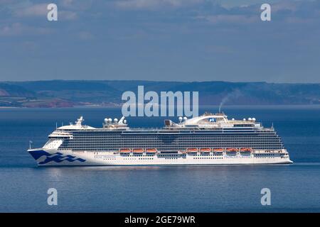 The huge Regal Princess cruise ship sits in waters off the coast of Torbay, Devon, UK. Stock Photo