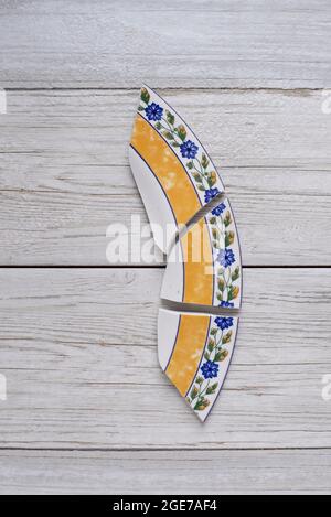 ceramic broken dish plate on wooden table.Flat lay Stock Photo
