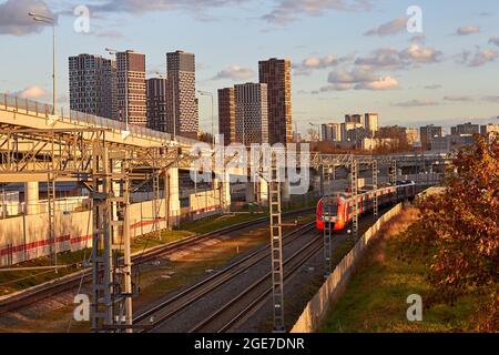 Modern high-speed train transports passengers against the background of city buildings - Moscow, Russia, October 15, 2020 Stock Photo