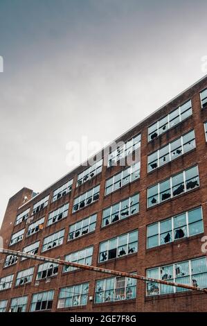 Abandoned office building in Old Trafford, Manchester, England, UK, with most of its windows smashed Stock Photo