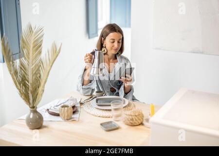 Woman having a breakfast at modern apartment Stock Photo