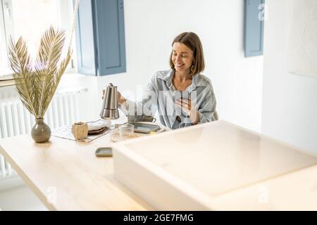 Woman having a breakfast at modern apartment Stock Photo