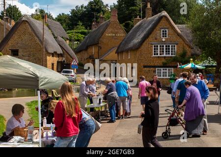 UK, England, Oxfordshire, Wroxton, annual church fete in progress, visitors at raffle stall in Main Street, near village duck pond Stock Photo