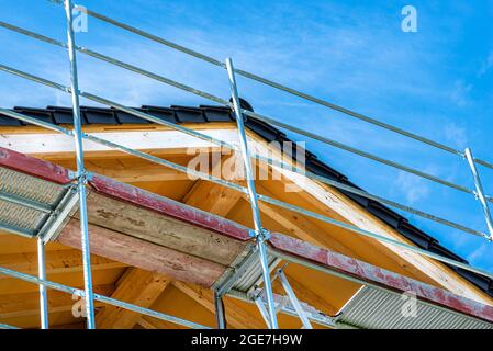The roof truss seen from below with chipboards nailed in, visible metal scaffolding. Stock Photo