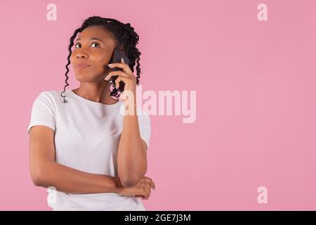 Afro american woman dreamily listening to her phone Stock Photo