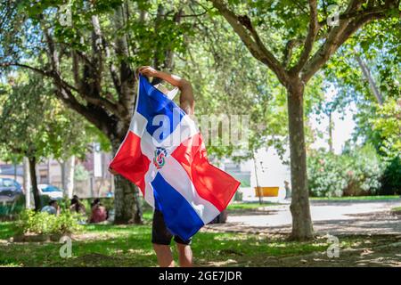 Latino man holding a Dominican Republic flag outdoors Stock Photo