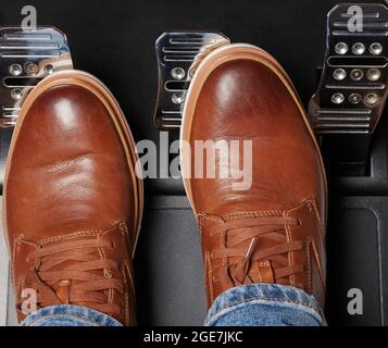 Man in casual brown leather shoes press car pedal above top view Stock Photo