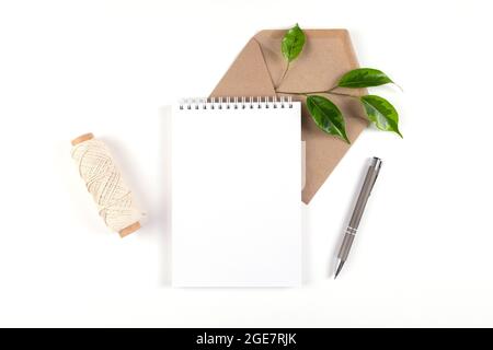 Notebook, recycled paper envelope and spool of plain coarse thread Stock Photo