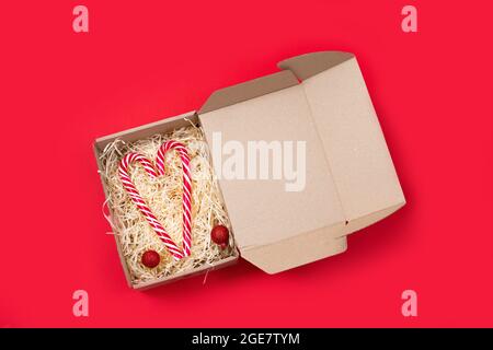 Heart shaped christmas candies candy cane in open gift box. Concept Christmas, New Year, minimalism. Flat lay, top view. christmas engagement Stock Photo
