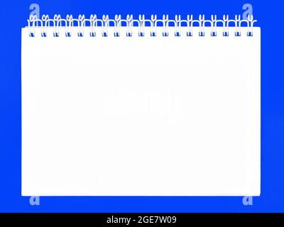 Notebook with spiral binder. Paper book isolated on blue background Stock Photo