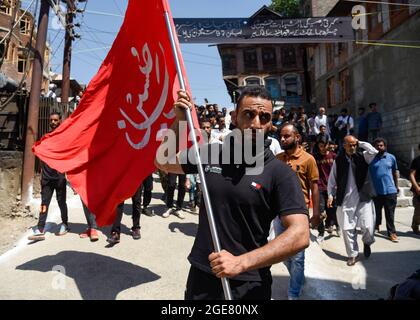 A Kashmiri Shia Muslim man hold a placard denouncing the burning of