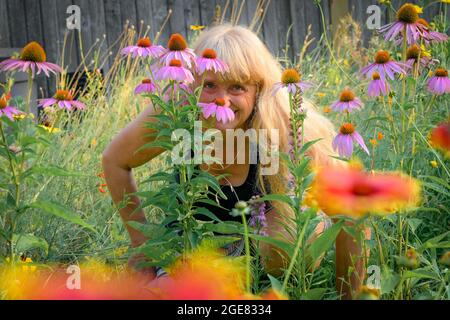 Playfull blonde woman in her  wildfower garden Stock Photo