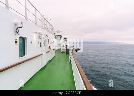 Deserted deck of a ferry in navigation on a cloudy day Stock Photo