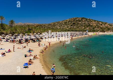 VAI, CRETE - 15 JULY 2021: Crowds of tourists on the picturesque palm fringed beach of Vai on the eastern coast of Crete (Greece) Stock Photo