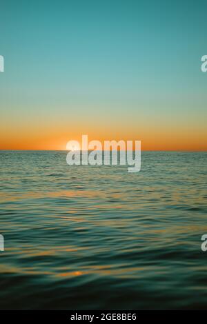 Sun rising over the water at Mollymook Beach. Stock Photo