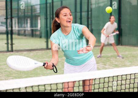Young emotional women playing paddle tennis outdoors Stock Photo