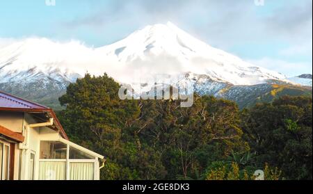 Cloud crossing the eastern side of Mt Taranaki in winter, from the Dawson Falls Lodge. Egmont National Park, NZ. Stock Photo