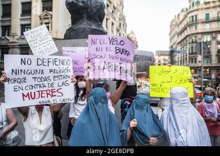 Barcelona, Spain. 17th Aug, 2021. Demonstrators seen wearing burqas while others display placards during the demonstration. Around a hundred women have participated in a feminist demonstration in front of the United Nations headquarters in Barcelona to demand an urgent international response to protect Afghan women and girls. Credit: SOPA Images Limited/Alamy Live News Stock Photo