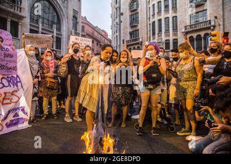 Barcelona, Spain. 17th Aug, 2021. Demonstrators are seen burning a burqa during the demonstration. Around a hundred women have participated in a feminist demonstration in front of the United Nations headquarters in Barcelona to demand an urgent international response to protect Afghan women and girls. Credit: SOPA Images Limited/Alamy Live News Stock Photo