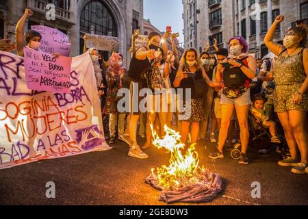 Barcelona, Spain. 17th Aug, 2021. Demonstrators are seen burning a burqa during the demonstration. Around a hundred women have participated in a feminist demonstration in front of the United Nations headquarters in Barcelona to demand an urgent international response to protect Afghan women and girls. (Photo by Thiago Prudencio/SOPA Images/Sipa USA) Credit: Sipa USA/Alamy Live News Stock Photo