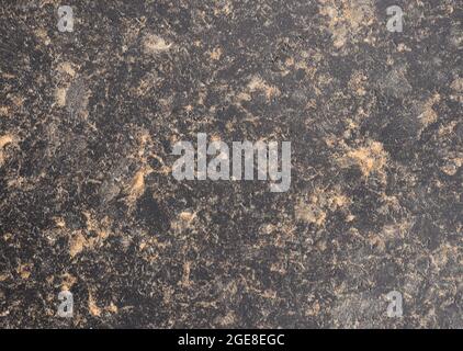Light black granite with small orange splashes, close-up of polished natural stone surface. Background, pattern, texture. Stock Photo