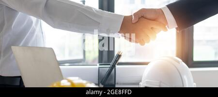 engineer handshake after successful contract and success deal, Architect and engineer construction workers shaking hands while working for teamwork co Stock Photo