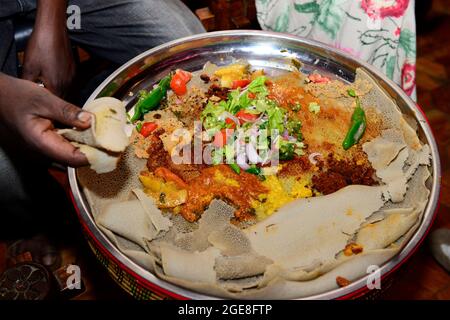 Ethiopians eating together an Injera dish at the Finfine cultural Restaurant in Addis Ababa, Ethiopia. Stock Photo