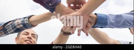Team work and brainstorming concept, hands of group engineer people put hand up together to be united and union on table in office Stock Photo