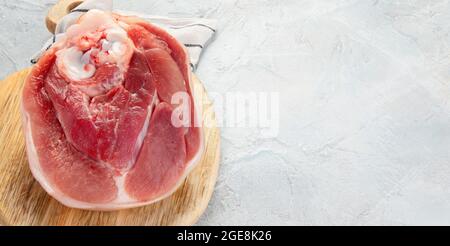 Raw ham leg on ligth gray background. Organic gourmet food concept. Top view, flat lay, copy space Stock Photo