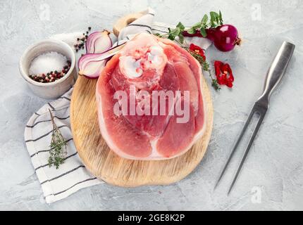 Raw ham leg on ligth gray background. Organic gourmet food concept. Top view, flat lay, copy space Stock Photo