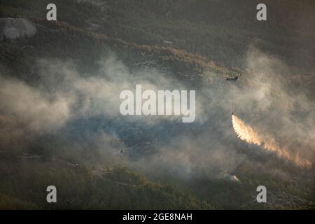 U.S. Army aircrews assigned to Bravo Company, 1st Battalion, 214th Aviation Regiment, 12th Combat Aviation Brigade, releases water from a bucket attached to a CH-47 Chinook as the crew flies in Western Turkey during an aerial firefighting mission Aug. 15, 2021. This is the first time that many of the crew members have fought fires. (U.S. Army photo by Staff Sgt. Christopher Stewart) Stock Photo