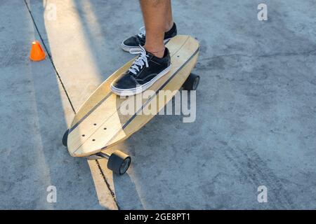 Close up top view young man leg on surf skate or skate board Stock Photo