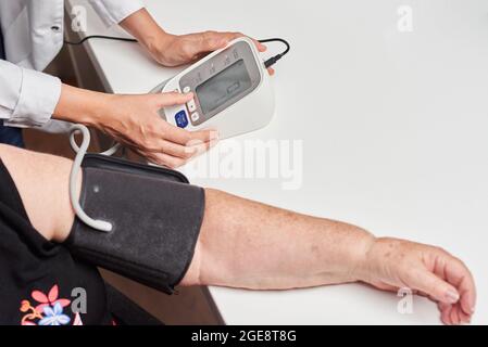 A female doctor measures a patient's blood pressure Stock Photo