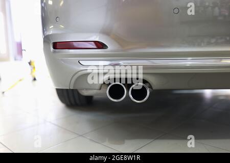 Exhaust pipe and back of new car in car service closeup Stock Photo