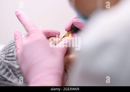 Permanent makeup artist makes eye arrows for client closeup Stock Photo