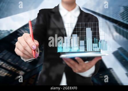 Lady In Uniform Standing Holding Tablet And Virtually Typing With Pen. Business Woman Carrying Pad Typing And Displaying New Futuristic Technologies. Stock Photo